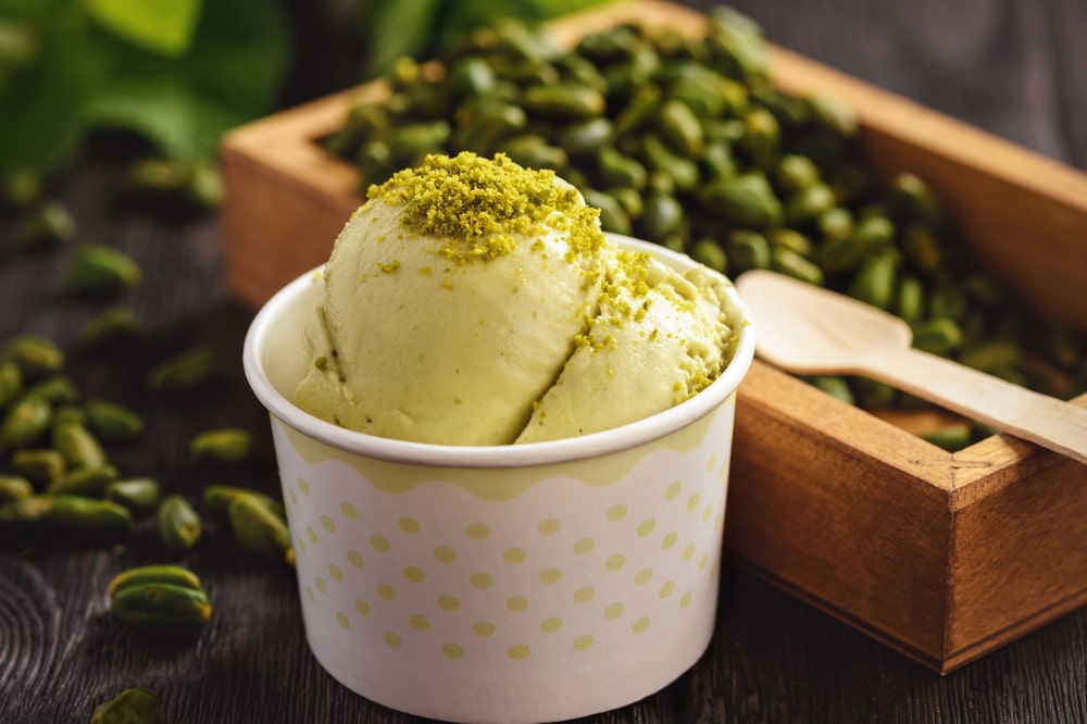 Pistachio Ice Cream In Paper Cup On Dark Wooden Background