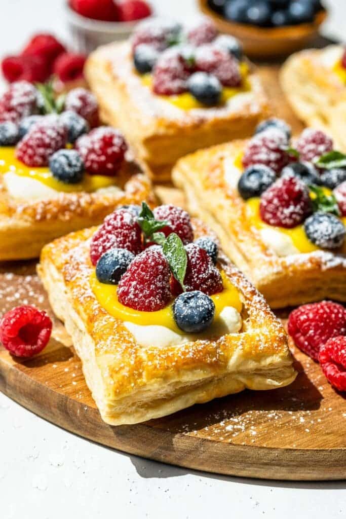 Cream Cheese and Lemon Curd Puff Pastry Tarts topped with fresh berries and dusted sugar