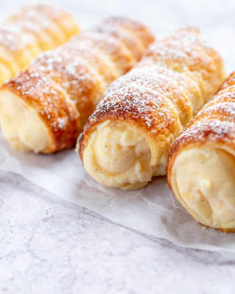 Crispy and creamy cannoli rolls with dusted sugar on top