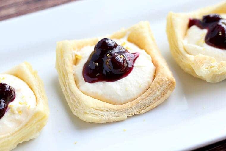 Shells for Lemon Cream Cheese Puff Pastry topped with cream cheese and blueberry sauce