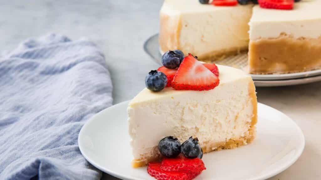 a slice of cheese cake with the blueberry and strawberry on top