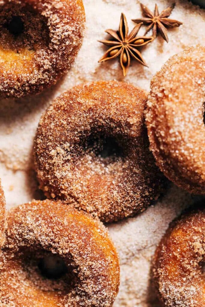 apple cider donuts dusted with sugar and pumpkin spice along with the star anise on side