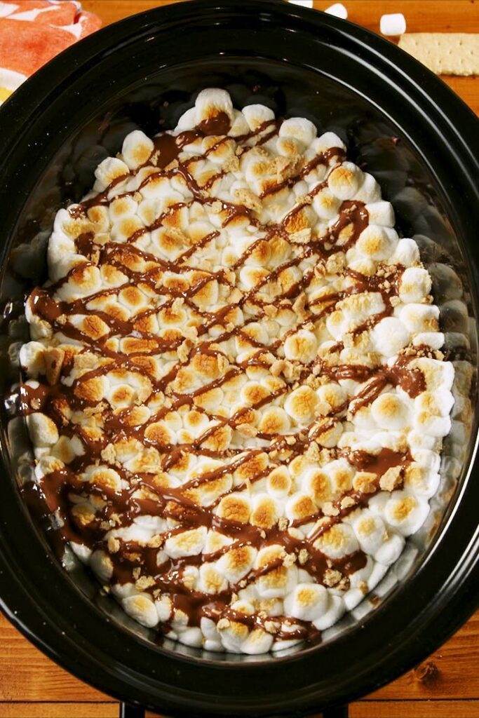 A top view of a creamy dessert with chocolate topping inside a crockpot