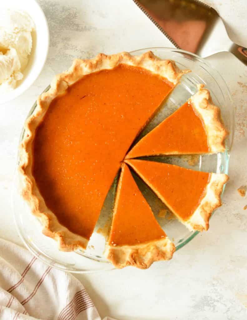 A top view of a sliced pumpkin pie