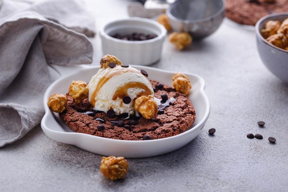 A view of a chocolate cookie with ice cream on top