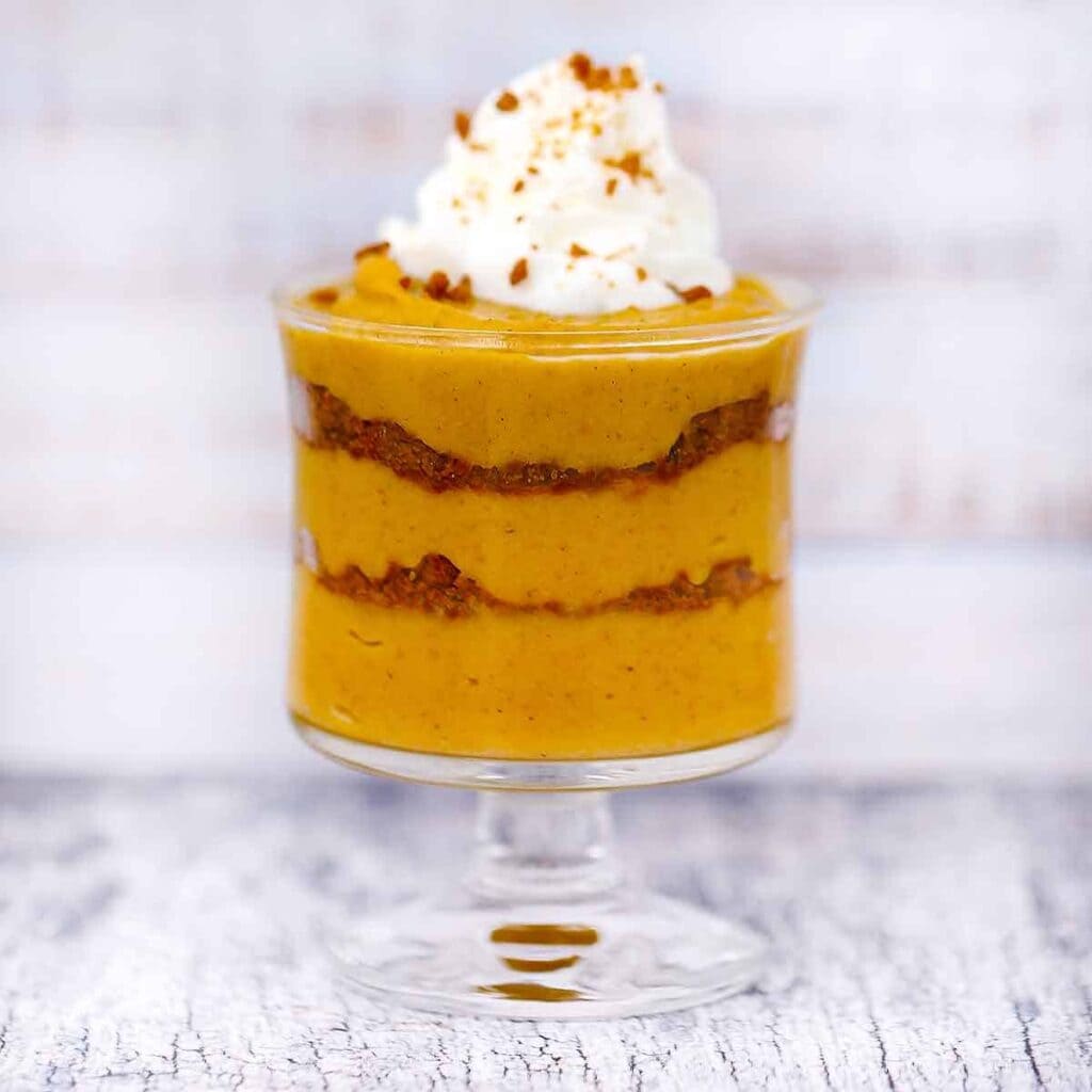 A view of a pumkin pudding dessert with cream on top