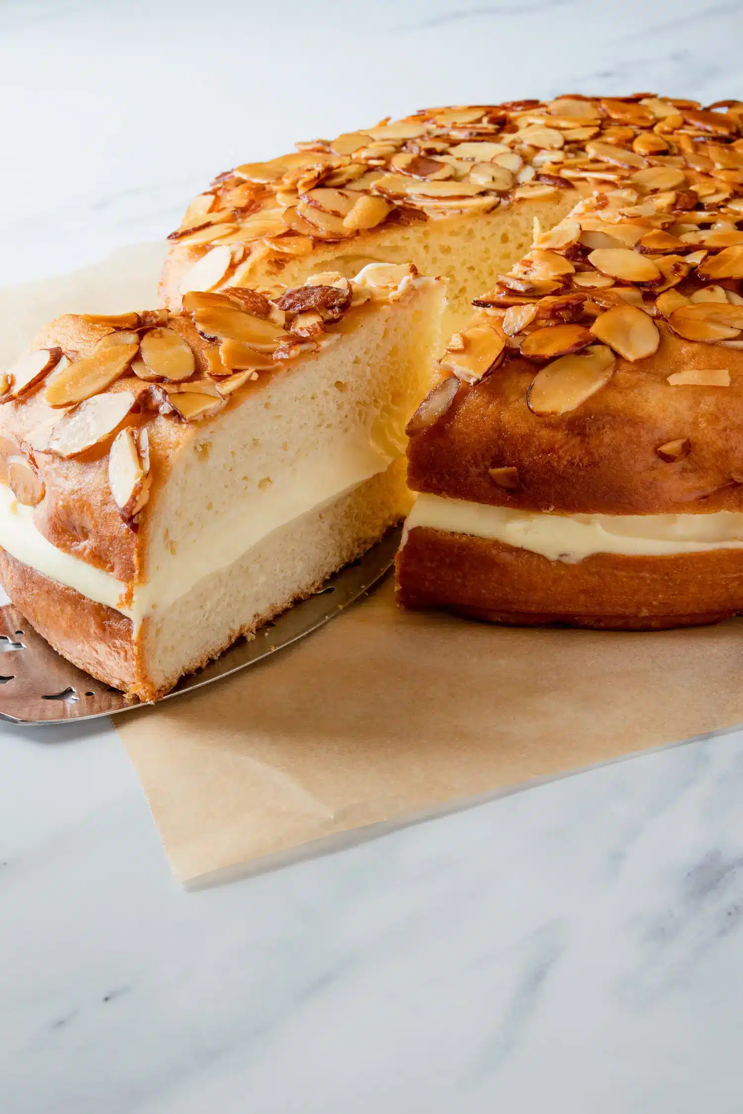 A view of a slice bieng taken out of the german bee sting cake with cream in between