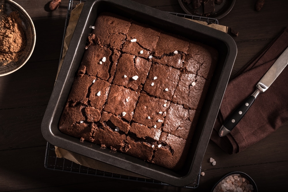 Fresh fudgy gluten-free chocolate brownies on dark wooden table