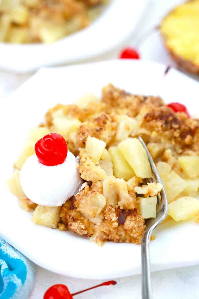 A view of pinapple crisp dessert with cream and cherry on top