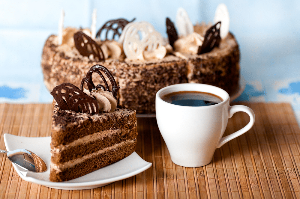 coffee a slice of cake on the plate on the background of cake