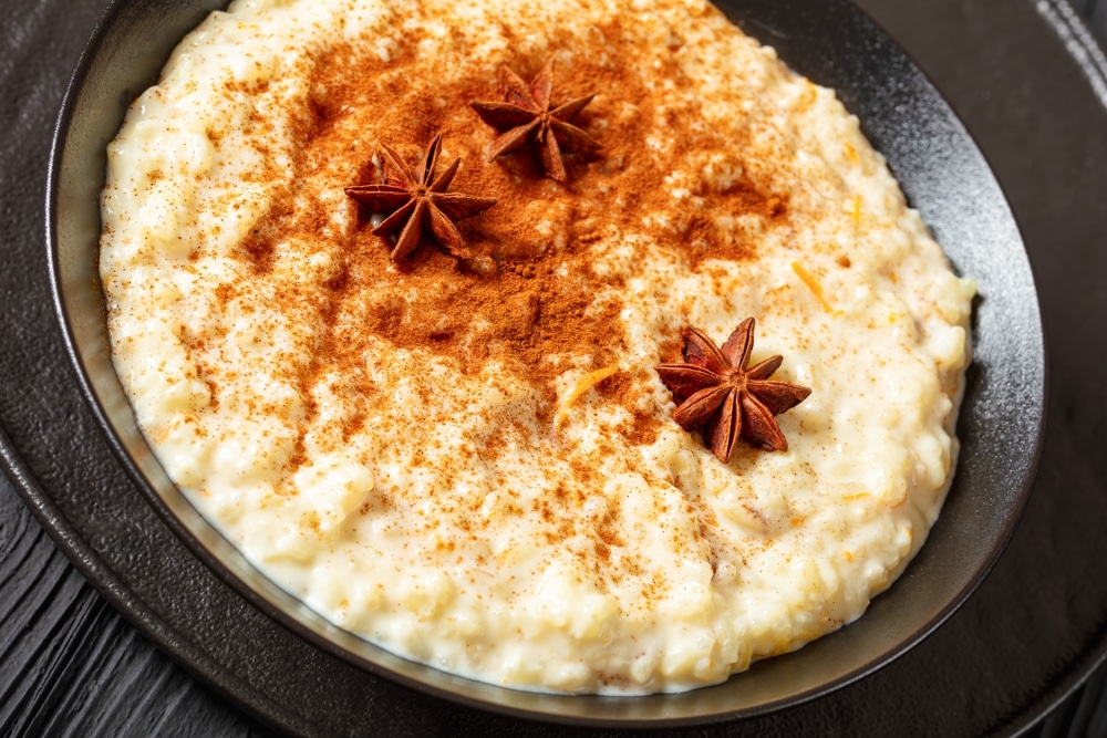 Rizogalo Creamy pudding in a black bowl garnished with star anise