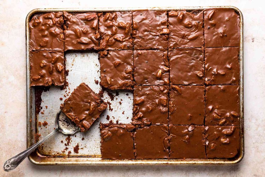 texas sheet cake with frosting in a baking tray and cut into squares