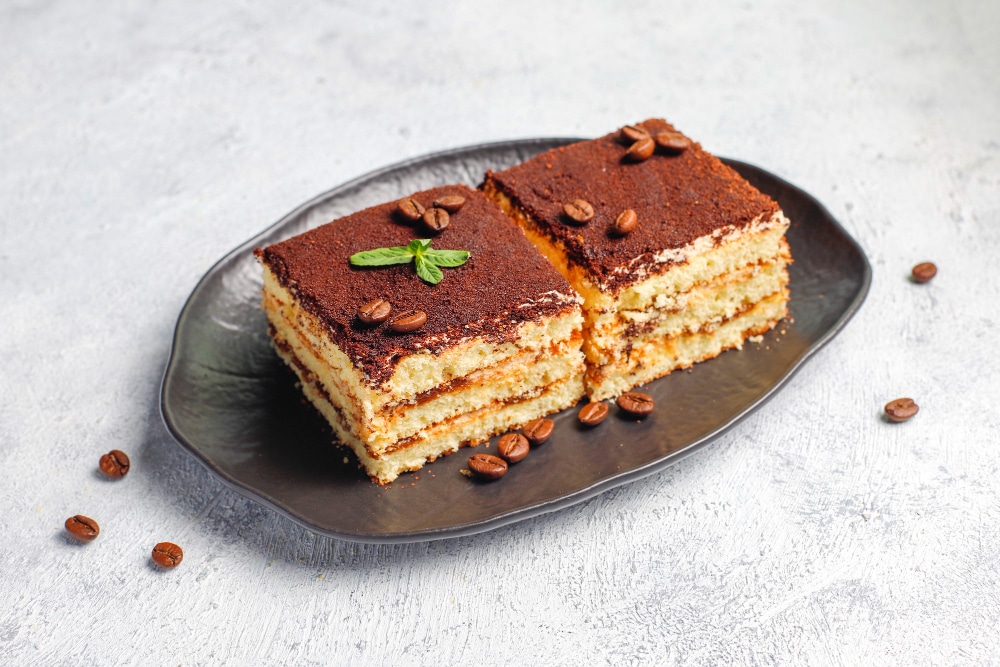 Tasty homemade tiramisu cake slices in a tray garnished with coffee beans 