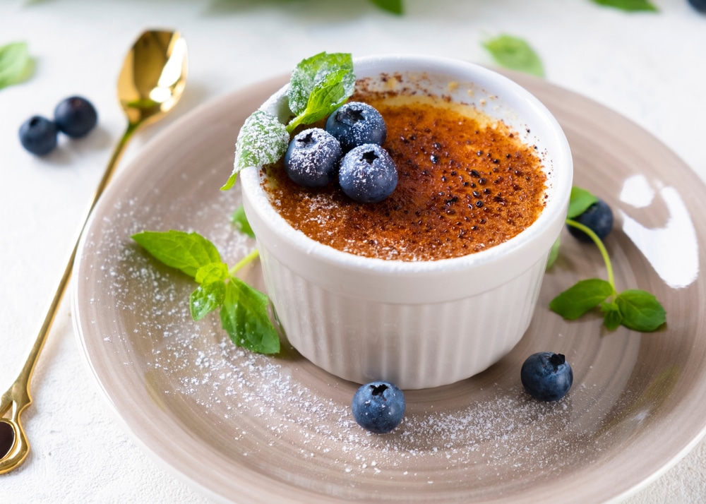 Creme brulee dessert with blueberries and mint leaves