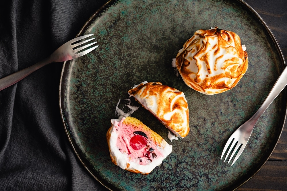 Mini Baked Alaska Desserts With Forks On A Dark Plate: