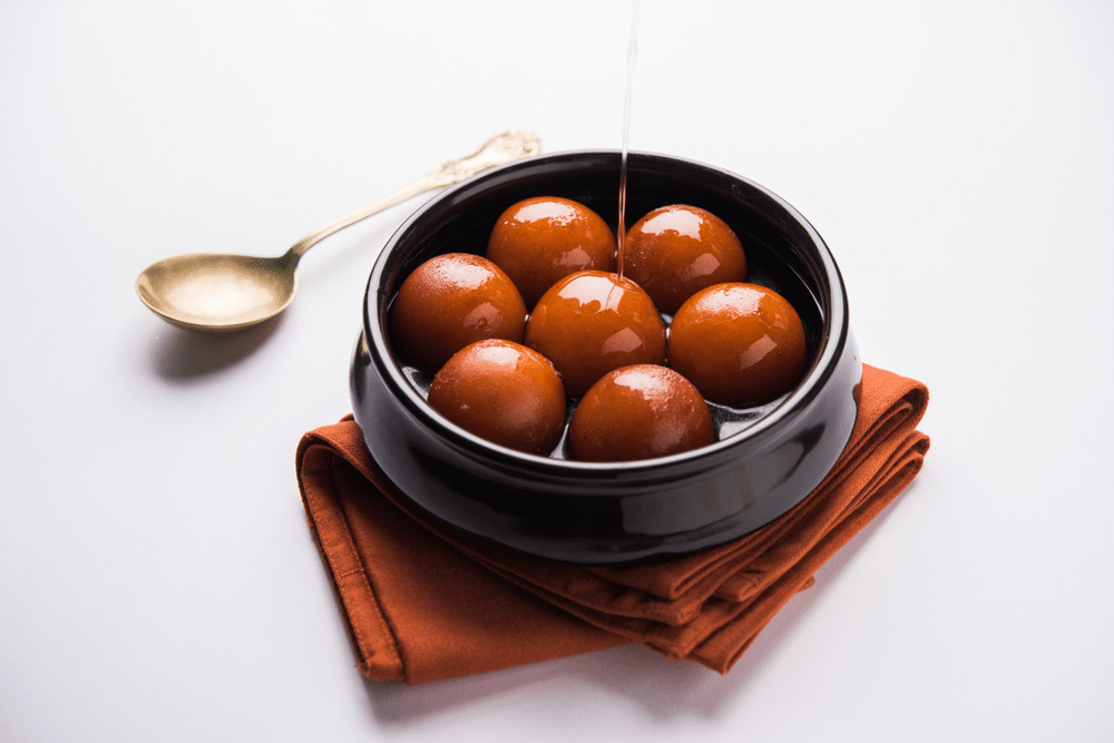 Sweet Gulab Jamun served in black ceramic bowl