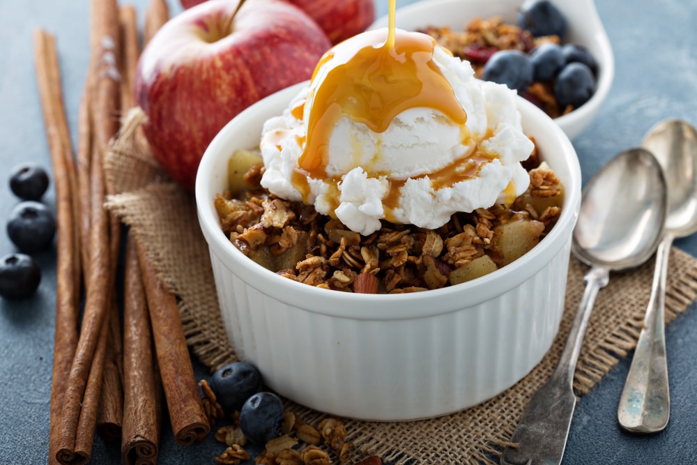 Apple crisp with vanilla ice cream with caramel sauce pouring over