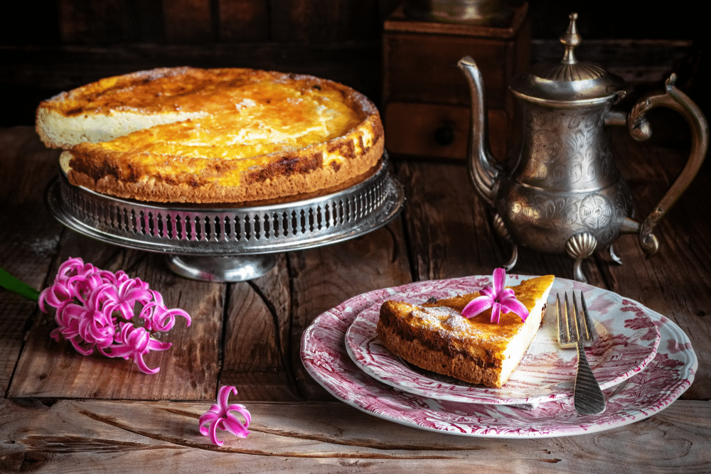 Homemade Italian ricotta cheesecake and pink hyacinths on wooden background