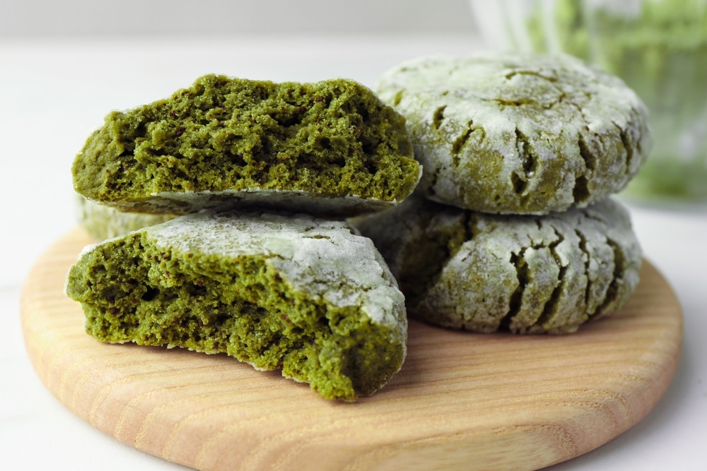 Board With Stacked Tasty Matcha Cookies On White Table Closeup